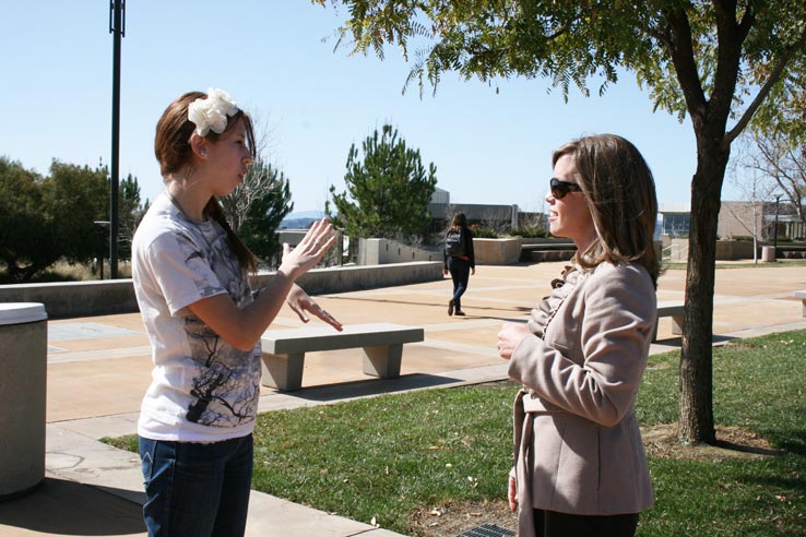 Two people practicing sign language.